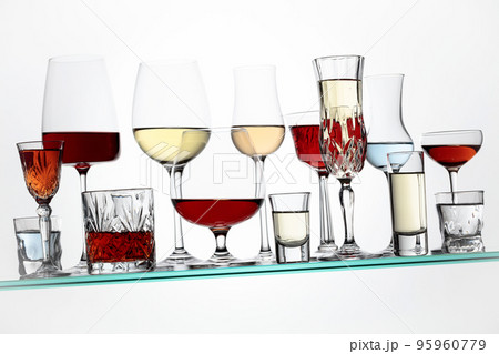 Alcoholic drinks on a tilted glass shelf. Alcoholic drinks on a tilted glass shelf. 95960779