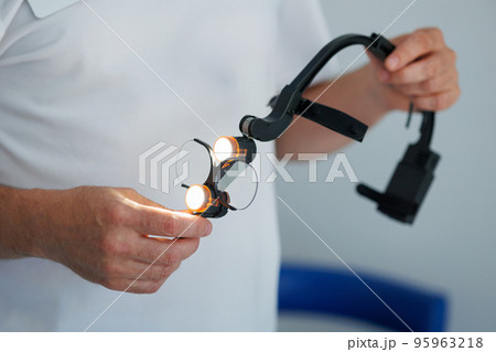 Dental binocular loupes in dentist hands 95963218
