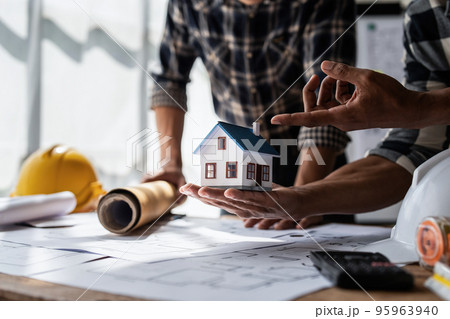 Architect team working with blueprints for architectural plan, engineer sketching a construction project, green energy concept 95963940