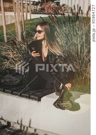 A woman on the street uses a mobile phone. online shopping. use of mobile applications. 95964727
