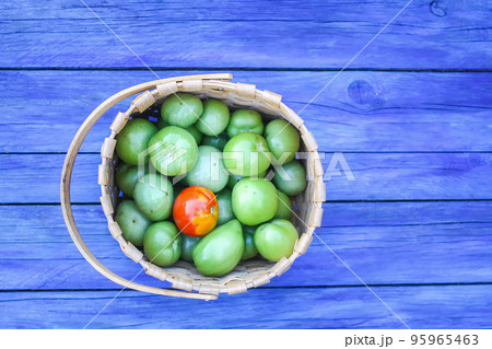 Zucchini and unripe tomatoes on wooden boards outdoors Zucchini and unripe tomatoes on wooden boards outdoors 95965463