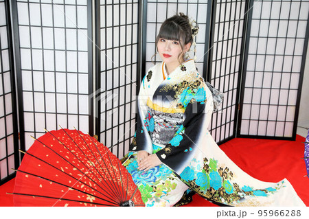 白地にターコイズブルー系柄の振袖を着た成人女性、和装スタジオ撮影、成人式 95966288