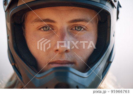Face, helmet and extreme sports with a man biker outdoor alone for adventure or adrenaline. Portrait, safety and motocross with a confident male rider outside alone for fun or recreation closeup Face, helmet and extreme sports with a man biker outdoor alone for adventure or adrenaline. Portrait, safety and motocross with a confident male rider outside alone for fun or recreation closeup 95966763