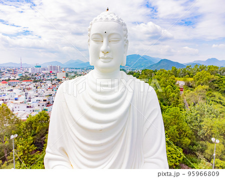 A white Buddha on a lotus flower. 95966809