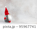 Christmas handmade gnome in red hat side view holiday banner on light winter background 95967741