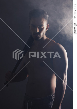 Baseball bat, fitness and man ready for a game on a black studio background. Sport, match and baseball player holding a bat ready to play sports on a dark backdrop for exercise, health and training 95967825