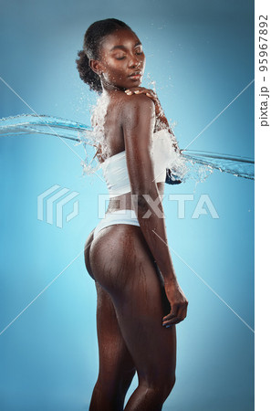 Beauty, water splash and skincare, black woman in underwear, blue background in studio. Fashion, health and fresh clean water for woman with healthy mindset, lifestyle body positivity in South Africa 95967892
