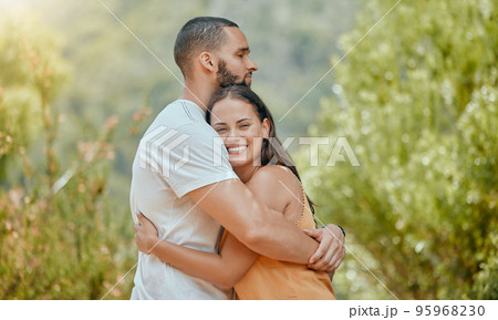 Love, hug and couple on a date in nature, happy and at peace together during summer. Relax, smile and young man and woman hugging with affection and bonding in a park or garden on a holiday 95968230