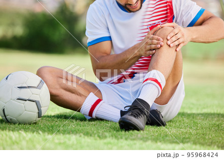 Fitness, knee pain or soccer player with injury for football exercise, sports training or training on grass soccer field. Sport, soccer athlete or man on ground for health or medical workout accident 95968424