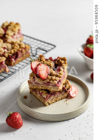 Two pieces of tasty oatmeal crumble strawberry bars on the plate Two pieces of tasty oatmeal crumble strawberry bars on the plate 95968509