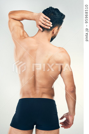 Back, body and underwear with a man model in studio on a gray background for health, wellness or care. Fitness, exercise and strong with a muscular male standing inside to promote healthy lifestyle Back, body and underwear with a man model in studio on a gray background for health, wellness or care. Fitness, exercise and strong with a muscular male standing inside to promote healthy lifestyle 95968510