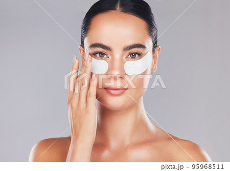 Skincare, face and woman with eye patches on a gray studio background. Health, beauty or female model from Spain with facial product, cosmetics pads or collagen eye mask for hydration or anti aging Skincare, face and woman with eye patches on a gray studio background. Health, beauty or female model from Spain with facial product, cosmetics pads or collagen eye mask for hydration or anti aging 95968511