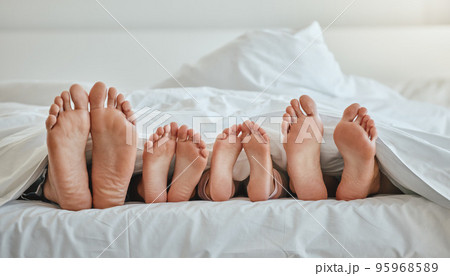 Morning, feet and family sleeping in bedroom for weekend, holiday or nap leisure in house. Relax, mother and dad with young children resting in bed with blanket in family home together. Morning, feet and family sleeping in bedroom for weekend, holiday or nap leisure in house. Relax, mother and dad with young children resting in bed with blanket in family home together. 95968589