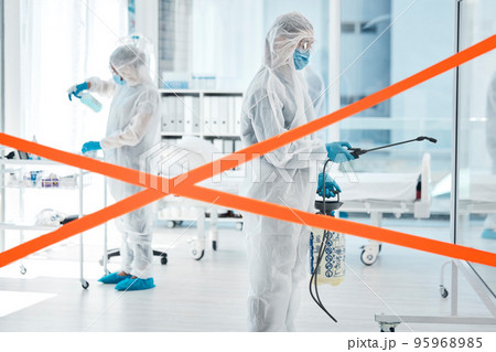 Covid, cleaning and red tape with medical team in hospital with ppe and spray for disinfection, hygiene and bacteria. Warning, virus and stop with healthcare worker in suit for safety and caution Covid, cleaning and red tape with medical team in hospital with ppe and spray for disinfection, hygiene and bacteria. Warning, virus and stop with healthcare worker in suit for safety and caution 95968985