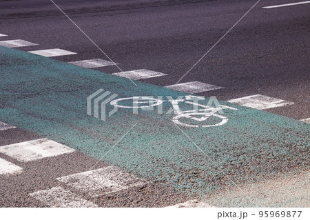 Green marked bike path on asphalt closeup Green marked bike path on asphalt closeup 95969877