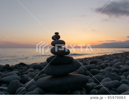 Stack of zen stones on the beach at sunset, beautiful seascape. Made of stone tower as rest balance vacation concept. 95970063