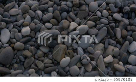 Sea stones background with small pebbles or stone in garden or in the seaside or on a beach. A close up view of rounded smooth polished pebble stones 95970105