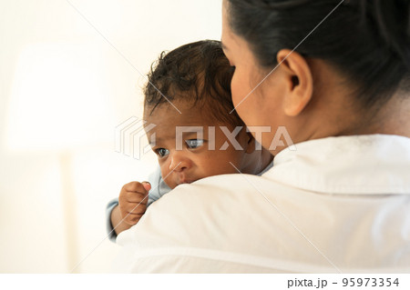 Happy Smiling mother holding adorable newborn baby chubby cheeks 95973354