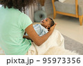 Mother African American holding one-month-old newborn baby gently. 95973356