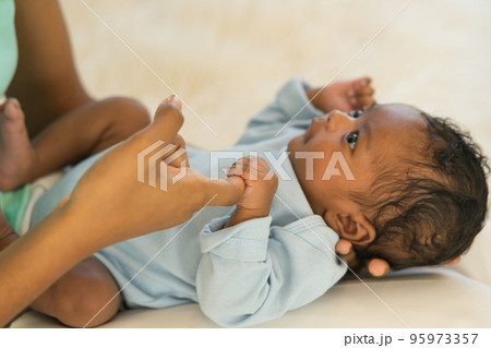 Newborn baby holding fingers mother's hand, Smile relax worry-free. 95973357