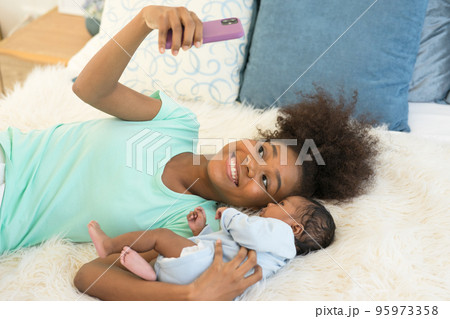 Young mother and newborn baby making video call and smiling greet 95973358