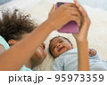 Young mother and newborn baby making video call and smiling greet 95973359
