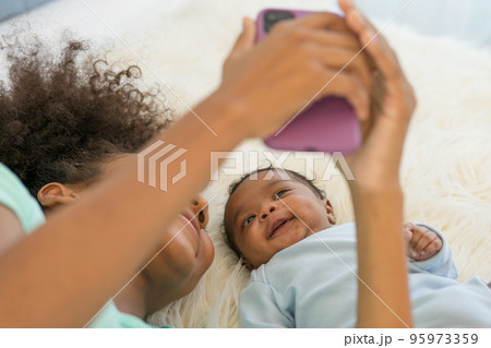 Young mother and newborn baby making video call and smiling greet 95973359