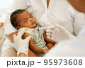 Close up hand of Doctor holding syringe to vaccinate newborn baby 95973608