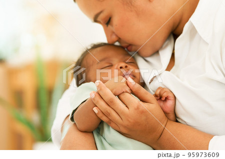Newborn baby one-month-old holding fingers mother's hand. 95973609