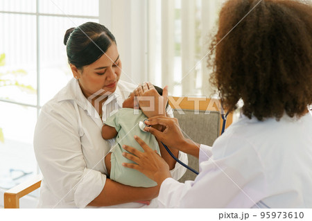 Newborn baby boy visiting the doctor for checkup health 95973610