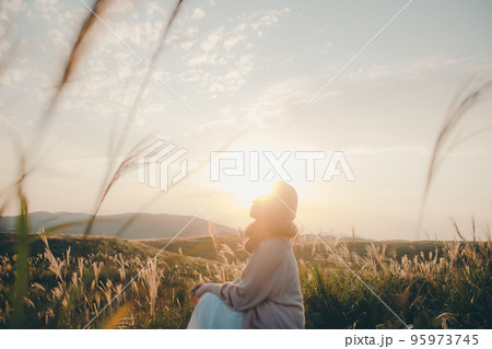 夕暮れの自然の中に佇む女性の写真 夕暮れの自然の中に佇む女性の写真 95973745