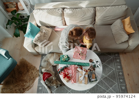 Family mother child and pet dog having fun together, kissing and decorating christmas gifts, top view 95974124
