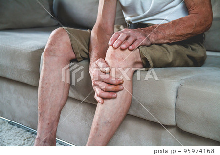 Pain in the legs and knees of an elderly seniorv 95974168