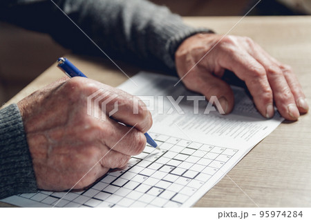 Senior solves sudoku or a crossword puzzle to slow the progressi Senior solves sudoku or a crossword puzzle to slow the progressi 95974284