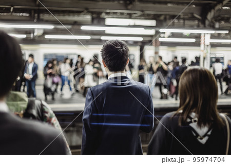 Passengers traveling by Tokyo metro. Business people commuting to work by public transport in rush hour. Shallow depth of field photo. 95974704