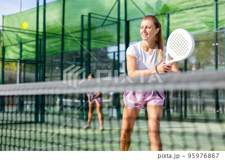 Active womans with enthusiasm playing padel on tennis court Active womans with enthusiasm playing padel on tennis court 95976867