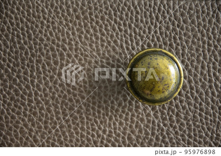 Antique brass knob on leather. Antique brass knob on leather. 95976898