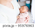 ママの抱っこで眠る赤ちゃん　新生児 95976963