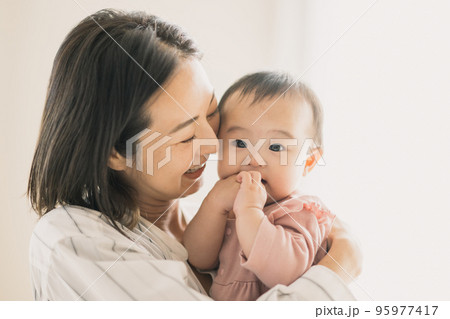 赤ちゃんを抱っこする笑顔のママ 95977417