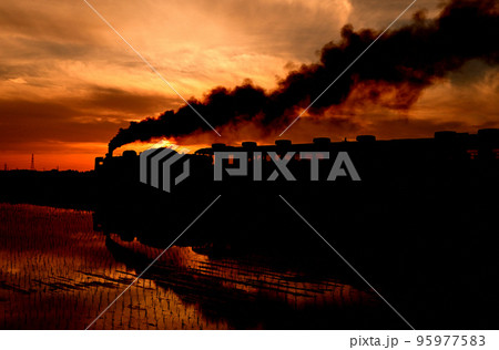 夕焼けの中を走る蒸気機関車 95977583