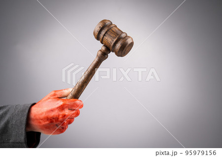 A female judge holds a gavel in a bloody hand on a white background. Copy space.  95979156