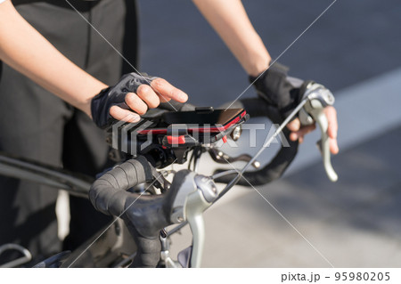 ロードバイクにスマホホルダーで取りつけたスマホナビを操作 95980205