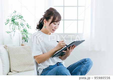 家でタブレットを使う女性（漫画家・お絵描き・小説家） 95980556