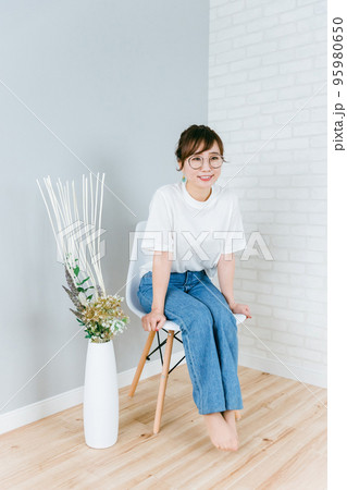 部屋で椅子に座るメガネをかけた日本人女性 95980650