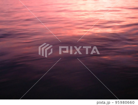 赤紫の淡い夕焼けが海面に映り込んだ風景素材 95980660