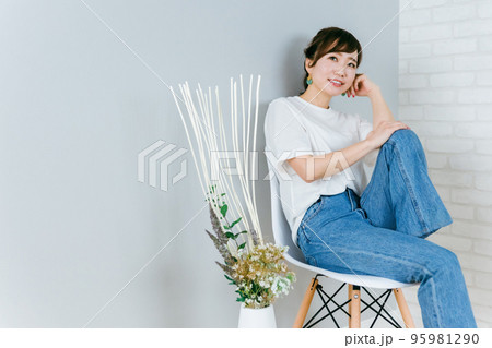 椅子に座って考えるおしゃれなジーンズ姿の日本人女性 椅子に座って考えるおしゃれなジーンズ姿の日本人女性 95981290
