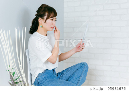 家で鏡を見てピアスをチェックするアジア人女性(ヘアセット) 家で鏡を見てピアスをチェックするアジア人女性(ヘアセット) 95981676
