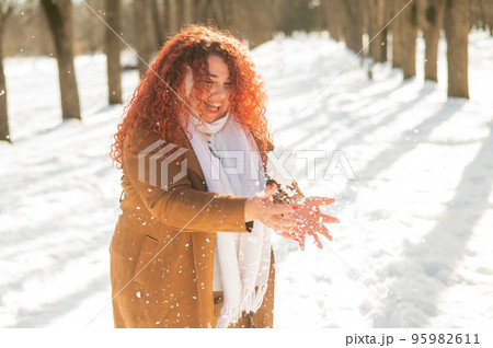Fat caucasian woman playing snowballs in the park. Fat caucasian woman playing snowballs in the park. 95982611