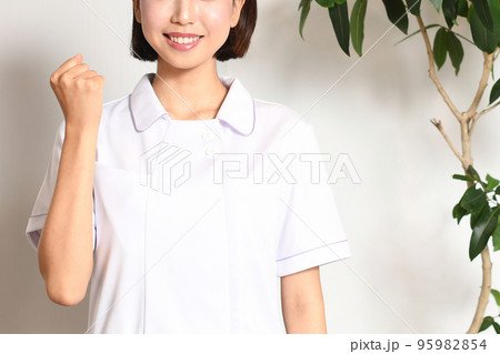 室内でガッツポーズをする医療従事者の女性 95982854
