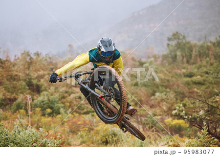 Mountain bike, man and air jump, action and bicycle stunt, challenge and adventure, freedom or dynamic risk in outdoor competition race. Biker athlete, sports adrenaline and energy for extreme sports 95983077